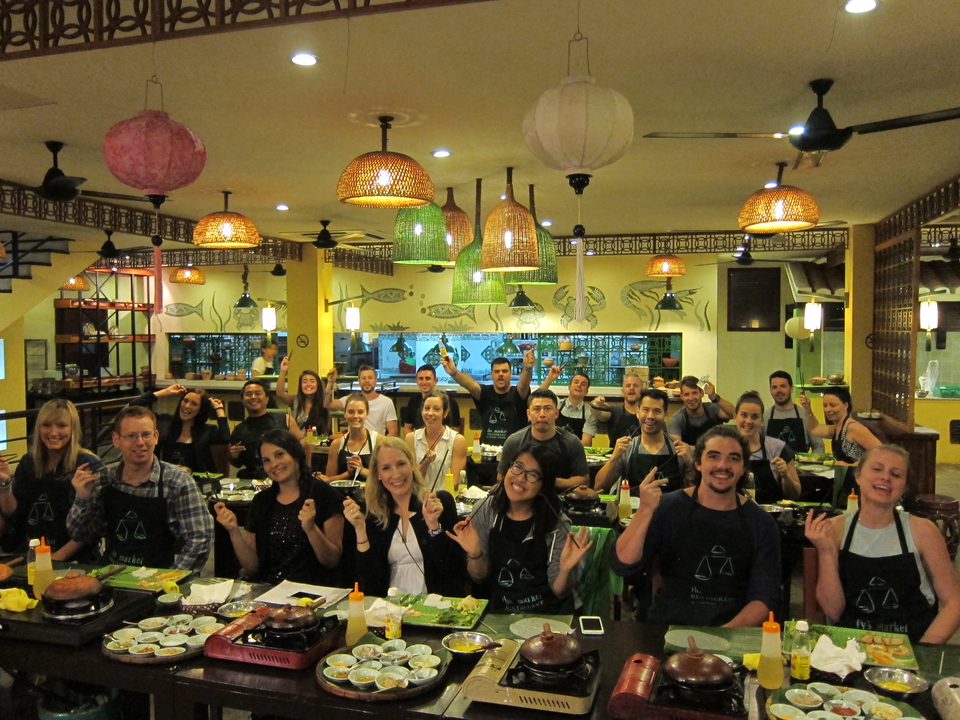 Large group of people enjoying a cooking class in a restaurant setting.