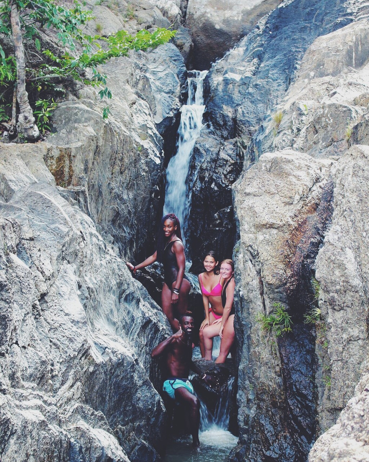 Group of friends posing by a waterfall.