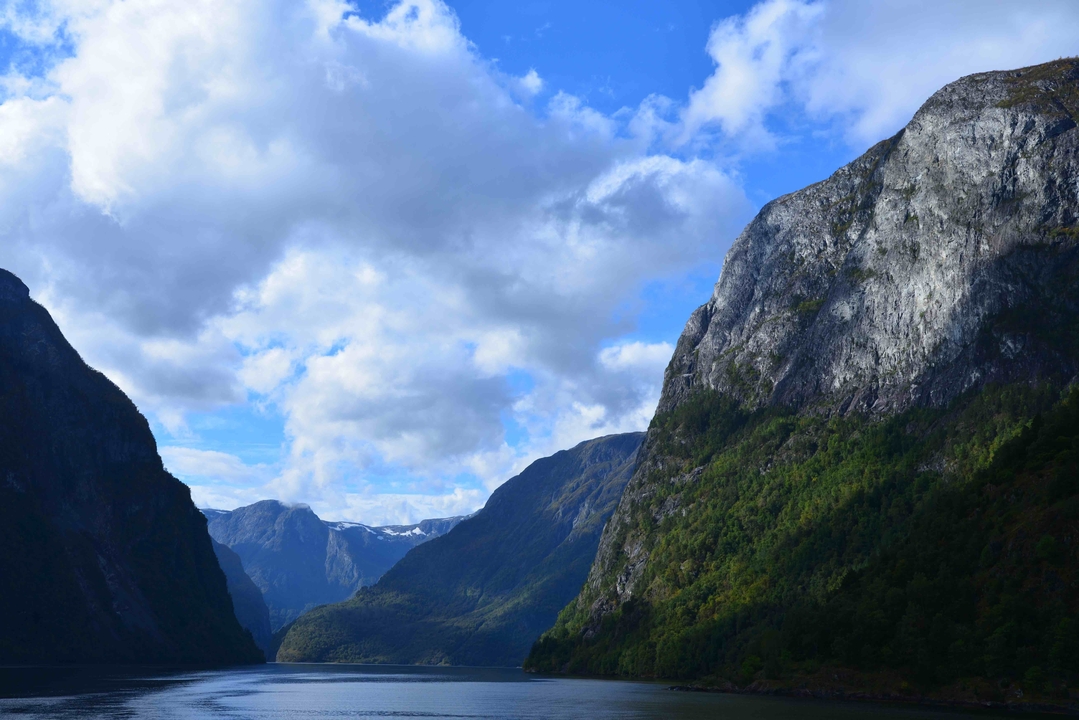 Steep mountains and dramatic sky view in a fjord.