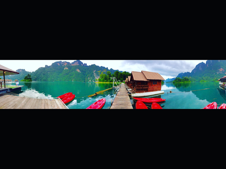 Floating bungalows with canoes on a lake.