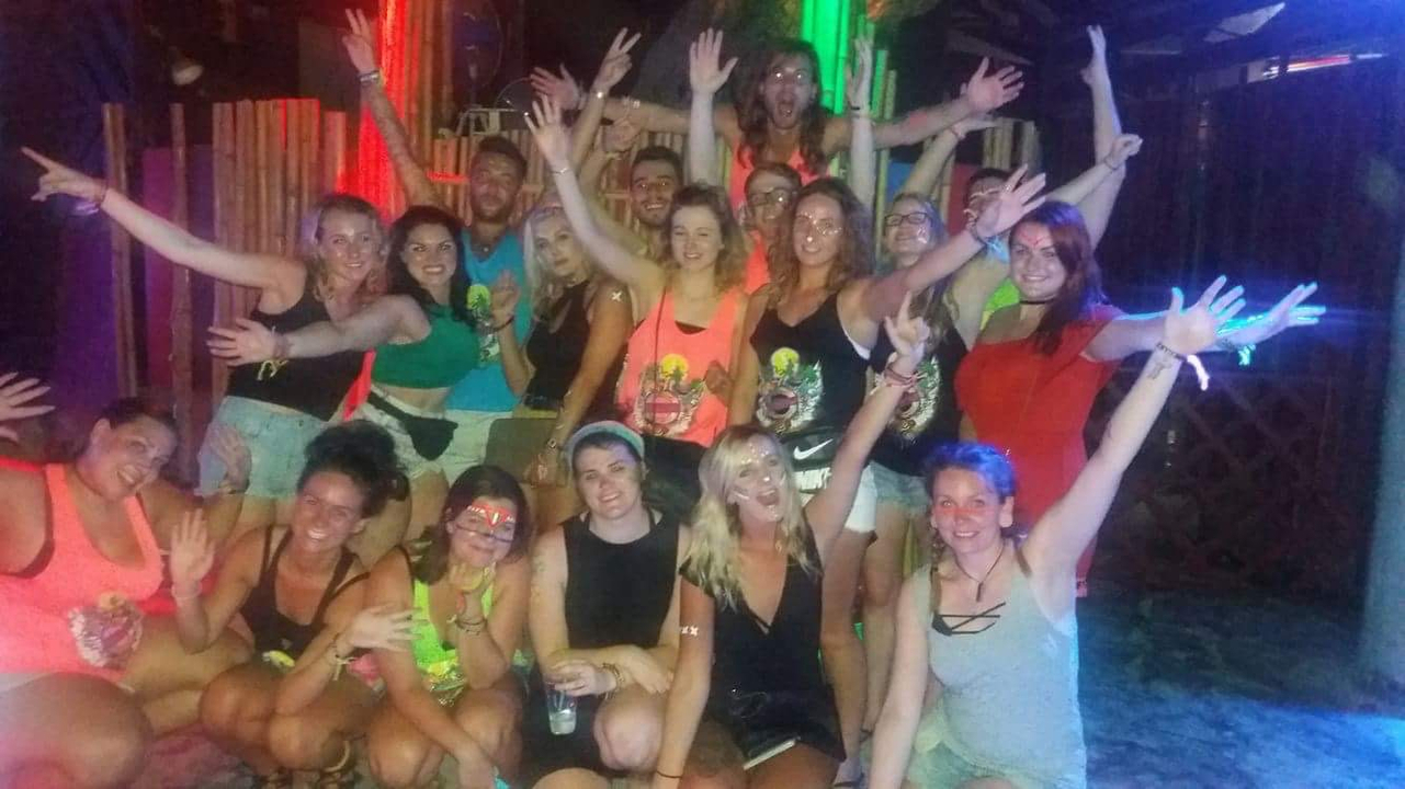 Group of people at a night party with bright lights.