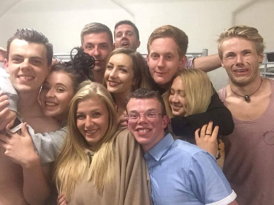 Group selfie of friends indoors in a lively setting.