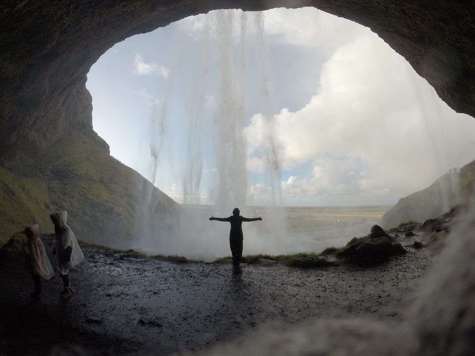 Person silhouetted behind a waterfall in Iceland.
