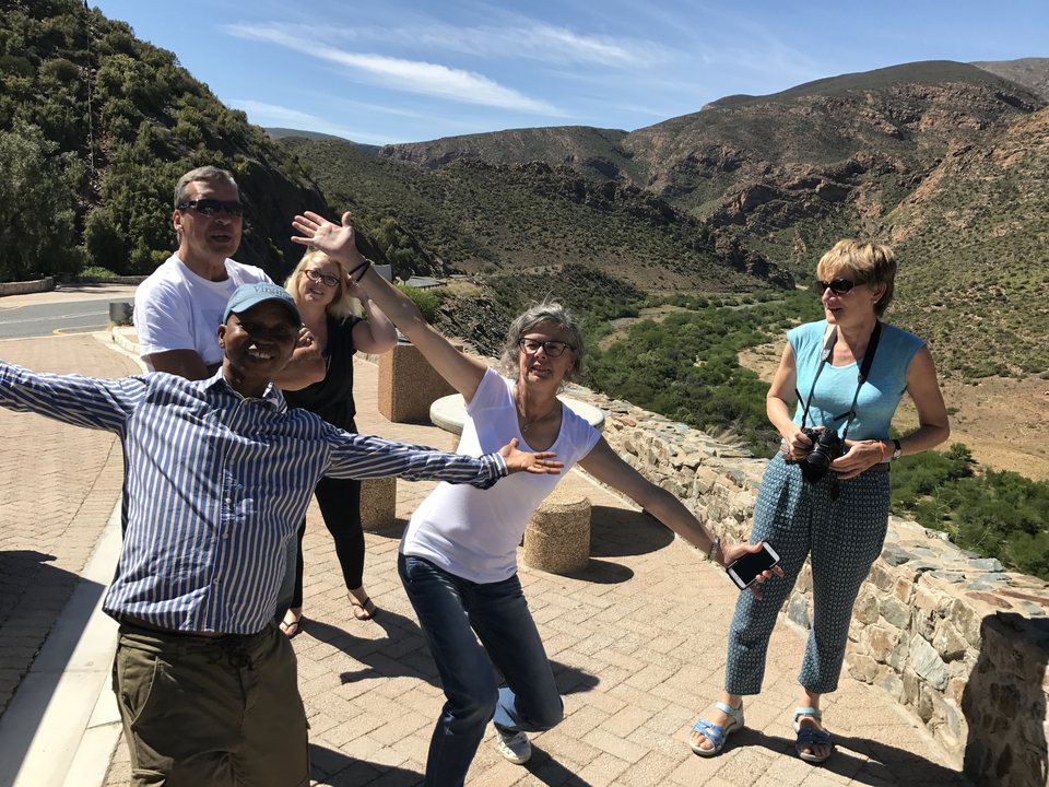 Group of friends posing playfully in a mountainous area.