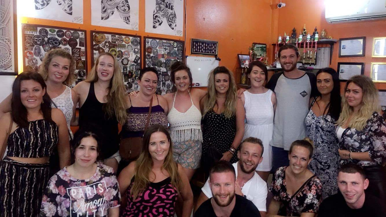 Group of friends posing indoors with colorful walls.