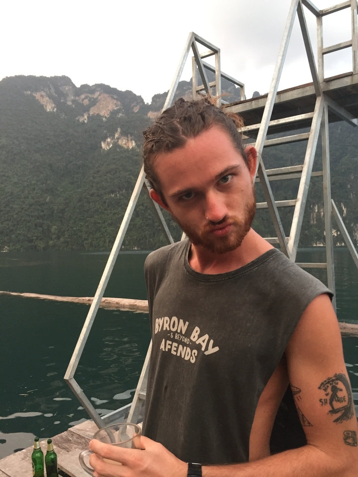 Une personne posant sur un bateau avec une vue panoramique sur les montagnes et l'eau.