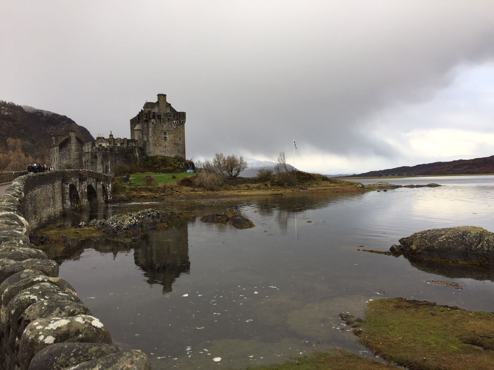 Castle with a reflection on the water and cloudy sky.