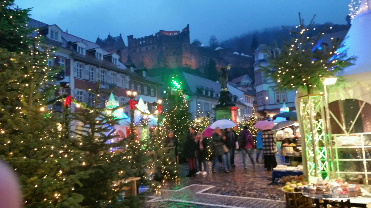 Christmas market with decorations and a castle in the background.