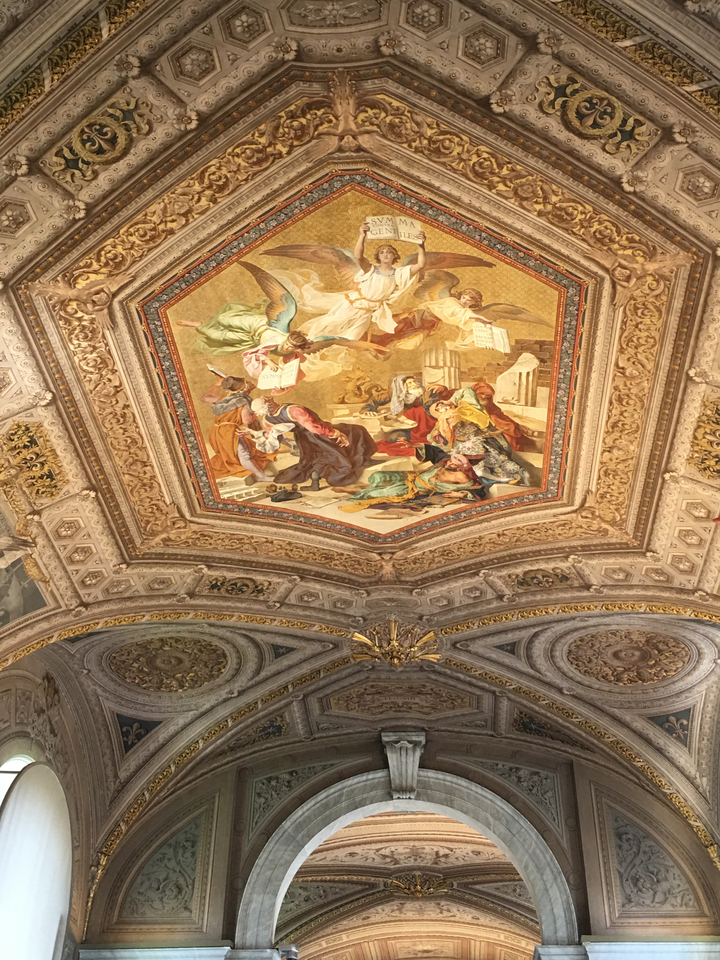 Intricate artwork on a ceiling, possibly in a historical building.
