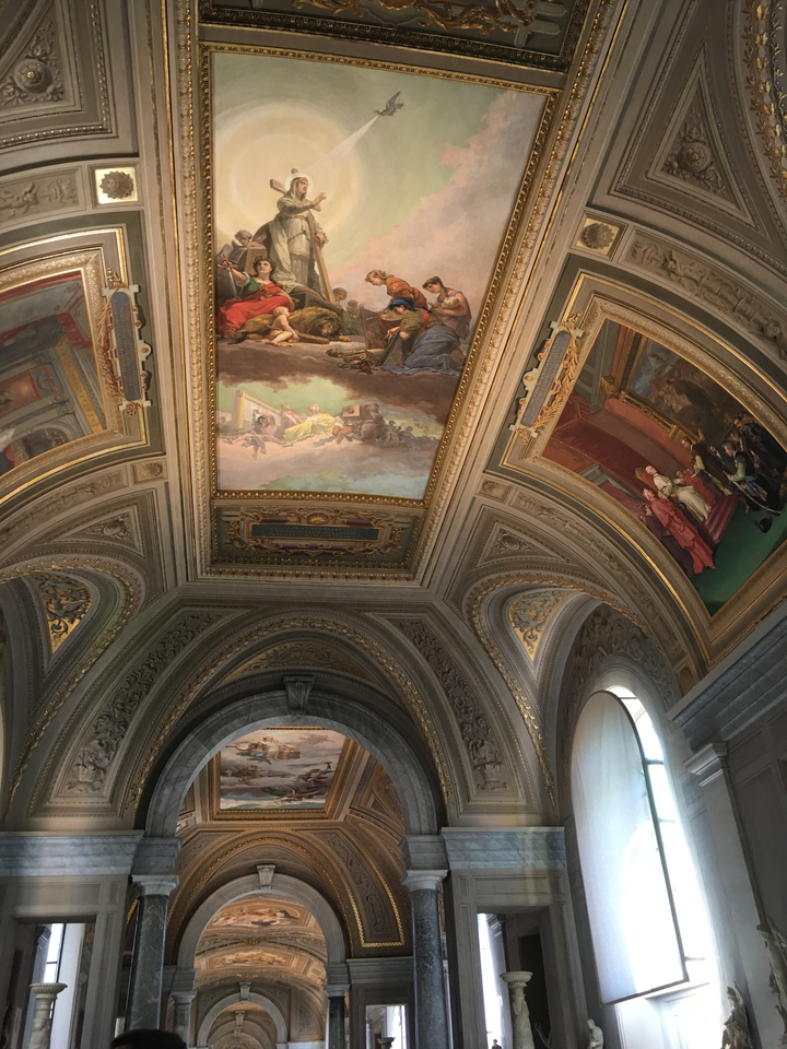 Ceiling of a building with intricate artwork and arches.