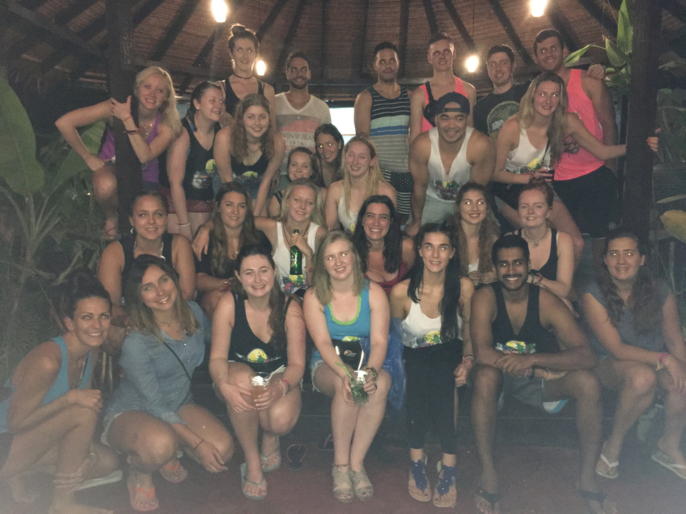 Large group of people posing together in a dimly lit environment.