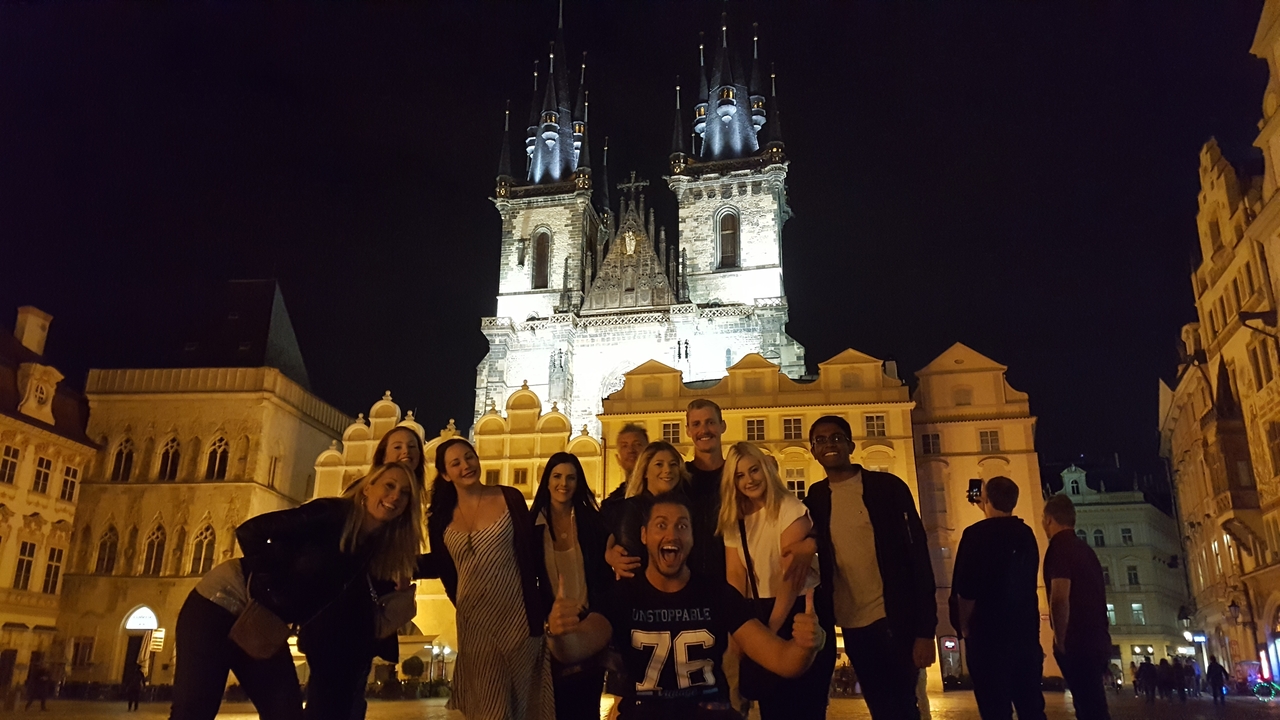 Group photo in front of a lit historical building at night.