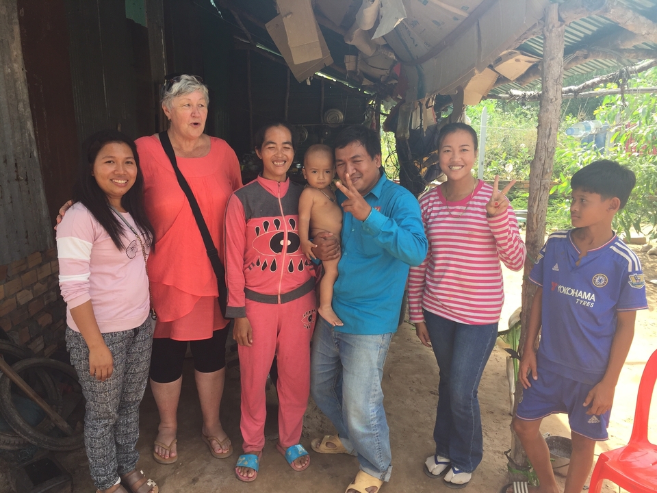 Groupe de personnes souriantes se tenant ensemble dans un village local.