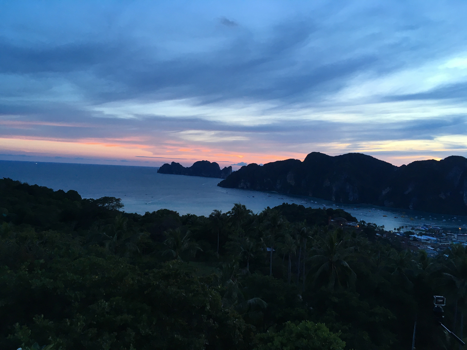 Beautiful sunset view over a bay with silhouetted mountains.