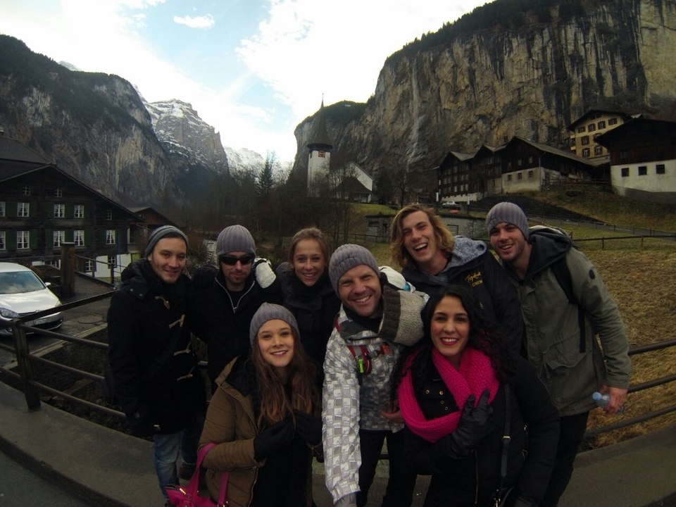 Group of people posing together in a mountainous town.