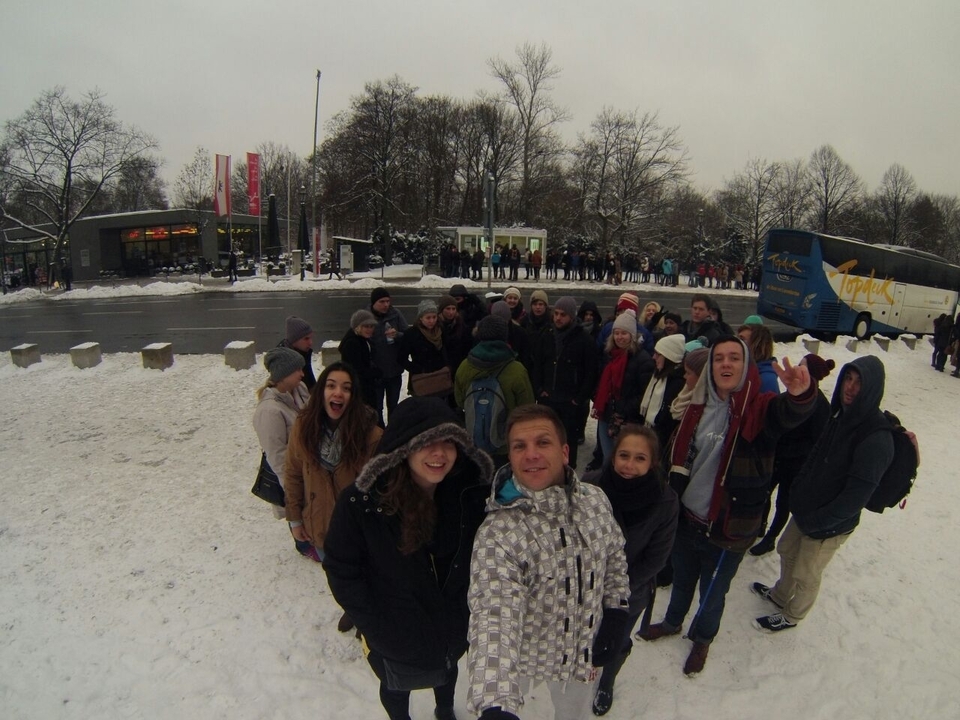 Group of people standing in a snowy environment wearing winter clothes.