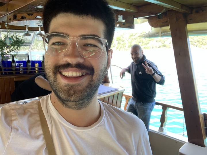 People smiling and posing at a dining area by the water.