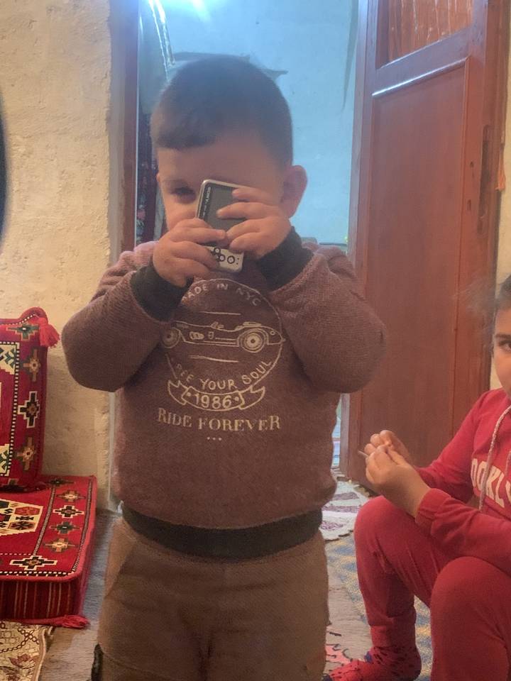 Child holding a toy camera indoors.
