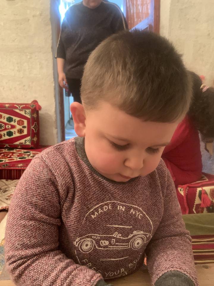 Child focusing intently on an activity indoors.
