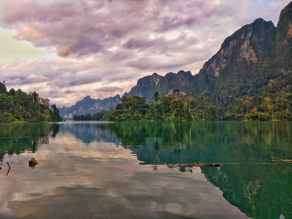 Beautiful lake surrounded by mountains and clouds.