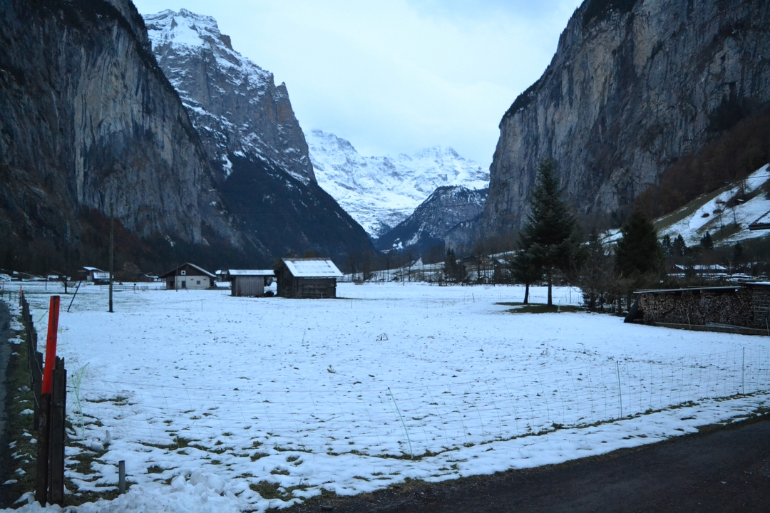 Snow-covered valley surrounded by mountains.