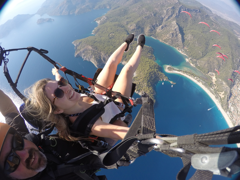 Parapente personnalisé avec vue sur la côte et les eaux bleues en contrebas.