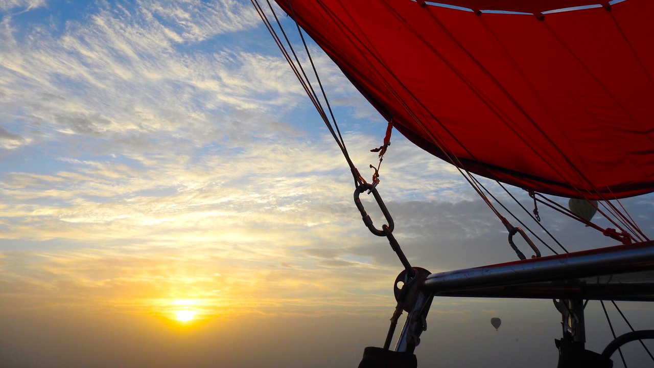 Hot air balloon with sunrise in the background.