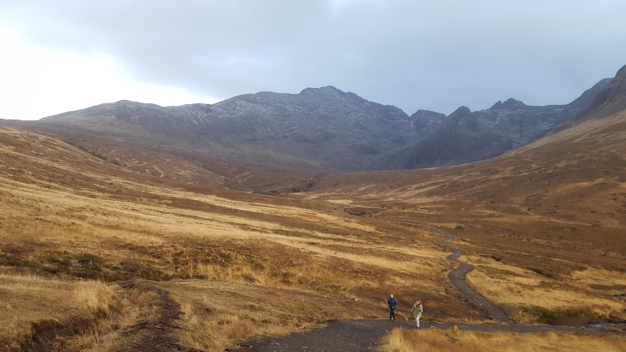 Two people walking in a vast valley