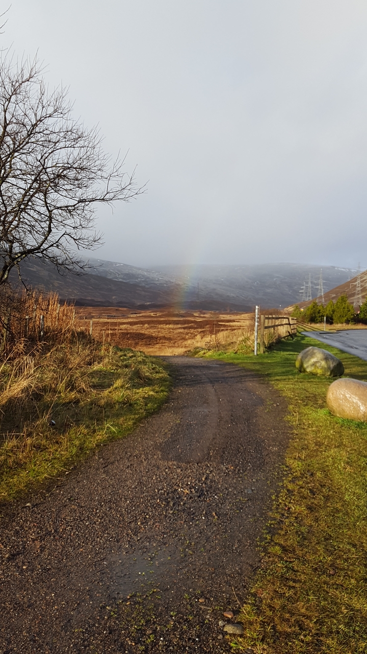 Rainbow in a hilly landscape with some clouds