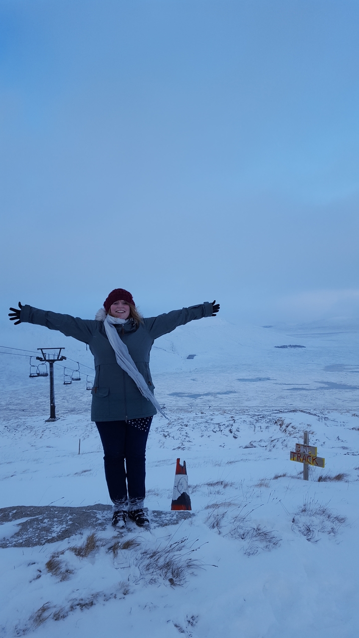 Person standing with arms outstretched in snow