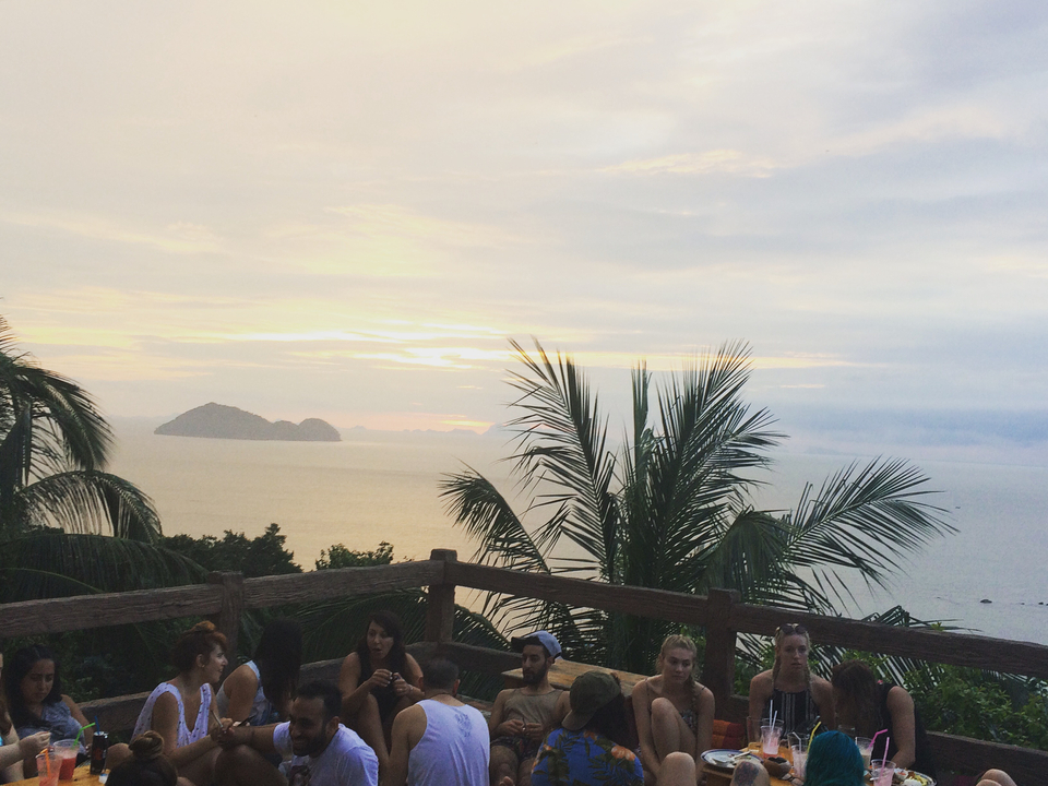 Sunset over the ocean with silhouettes of people