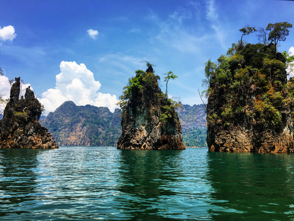 Rugged limestone cliffs rising from a tranquil lake.