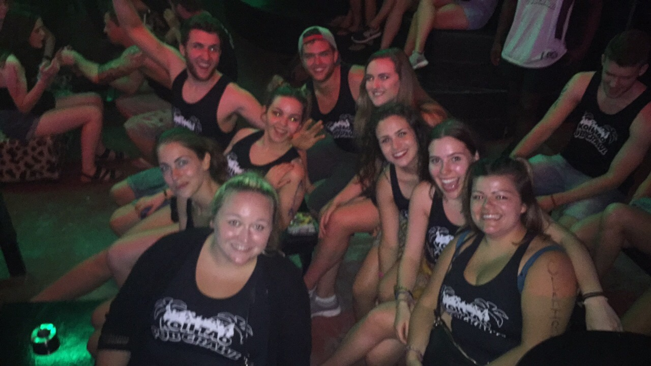 Group of people dressed in matching tank tops at a party.