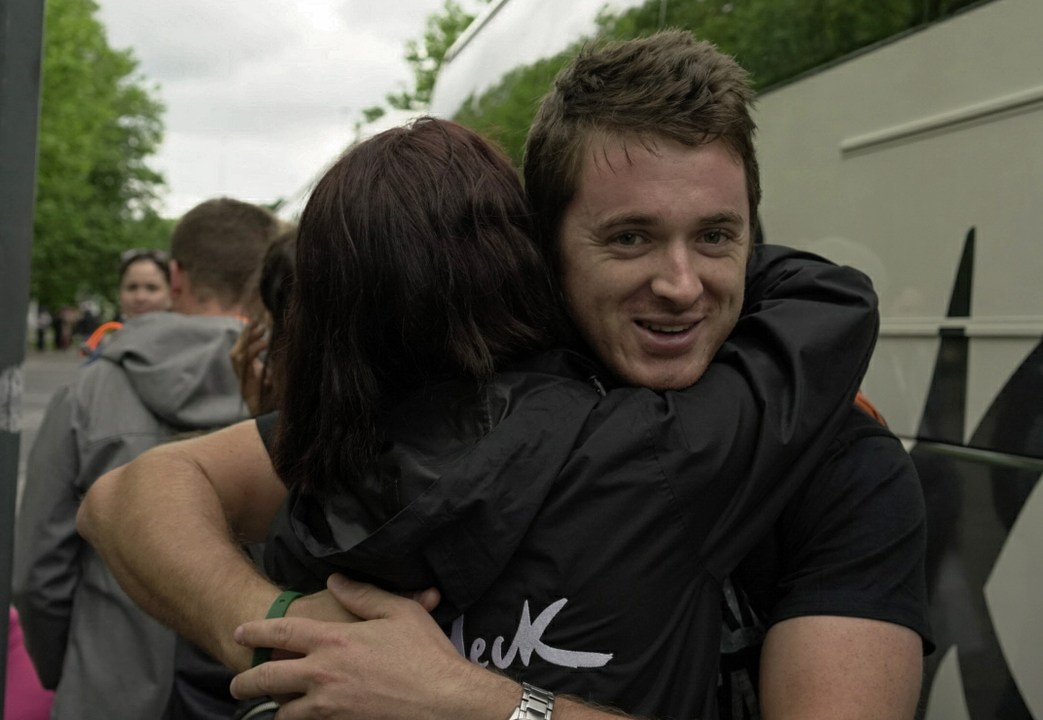 People hugging in an outdoor setting.
