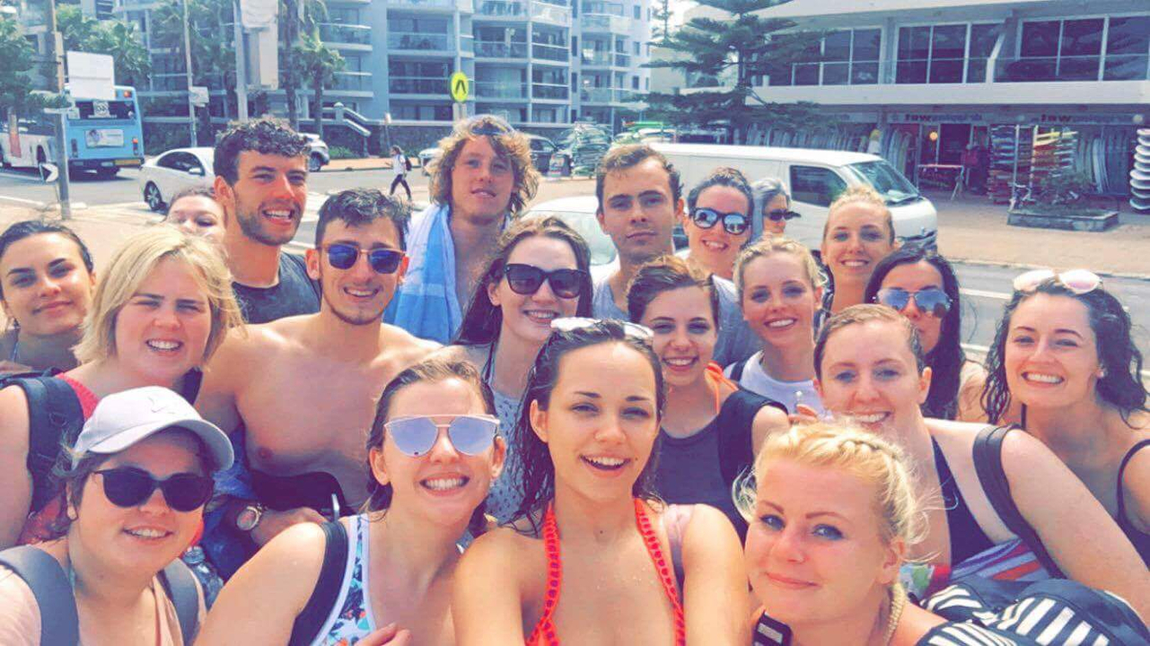 Group of people taking a selfie in an urban area.
