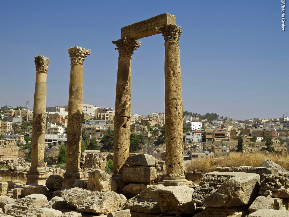 Ancient columns with a modern cityscape in the background.