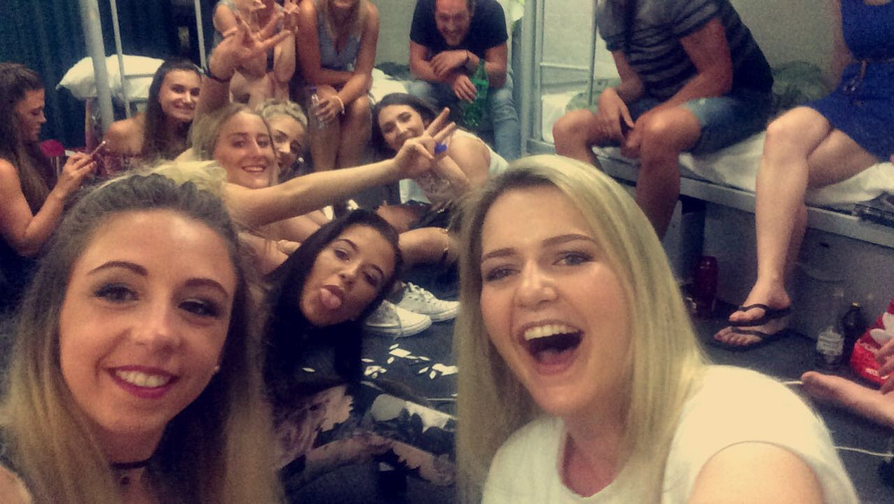 Indoor group photo with friends on a bed