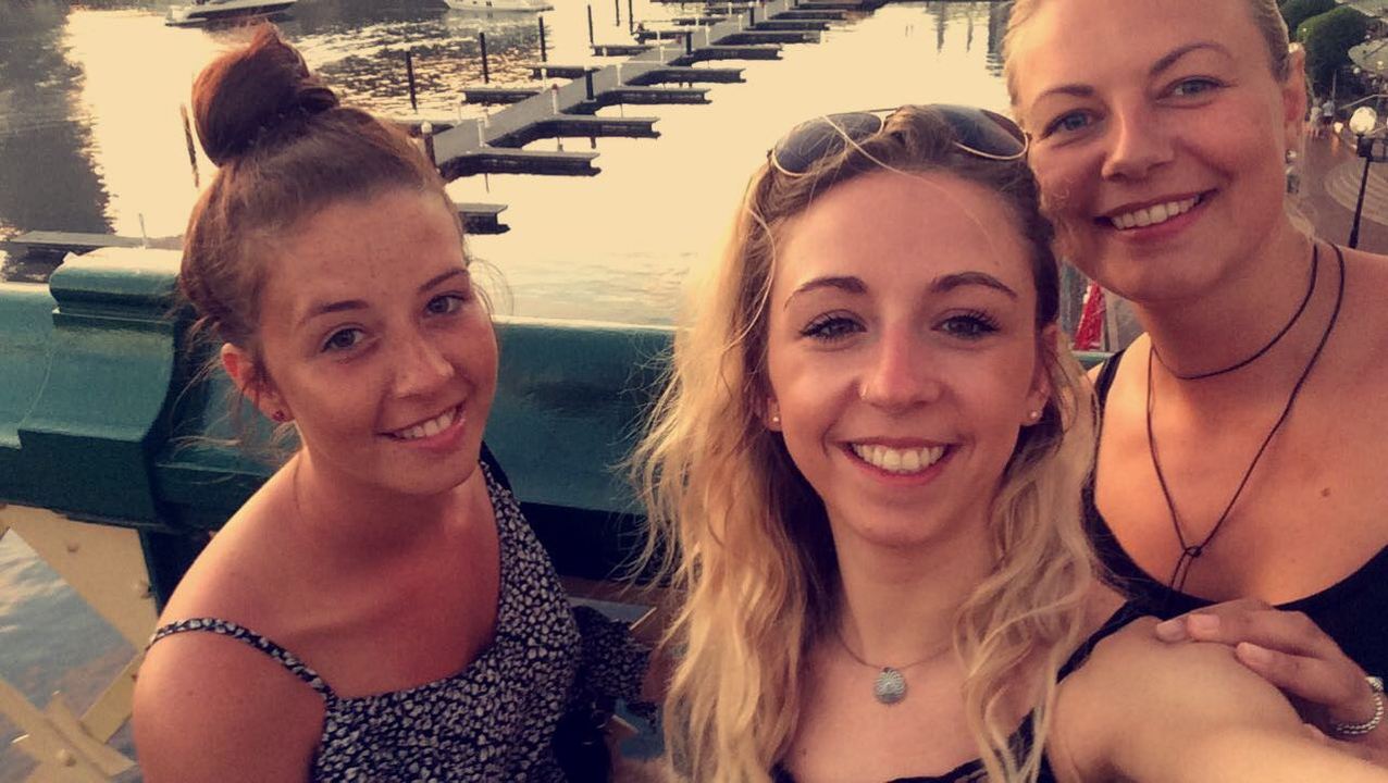 Group selfie of three women by a waterfront