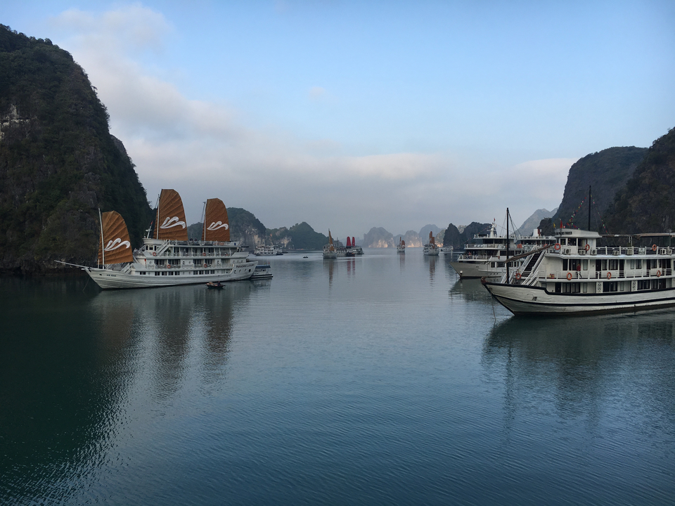 Cruise ships sailing in serene waters with rocky outcrops.