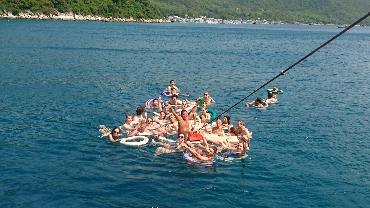 Large group of people floating in open water.