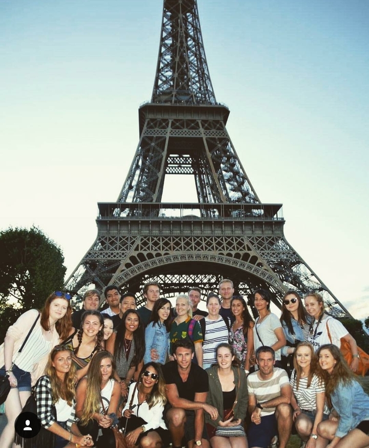 Group of people in front of the Eiffel Tower.