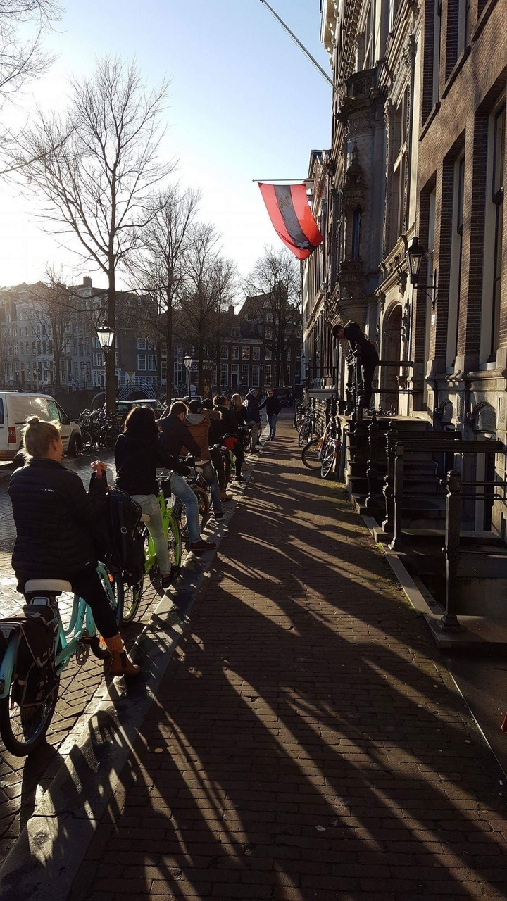 People bicycling on a street in Amsterdam.