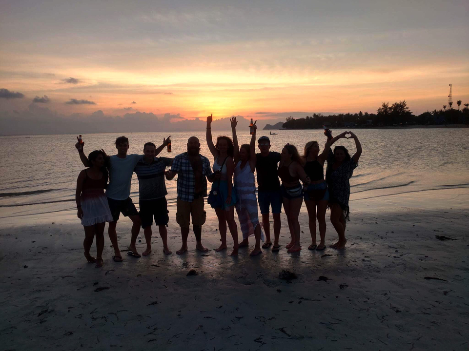 Silhouettes of people on a beach at sunset.