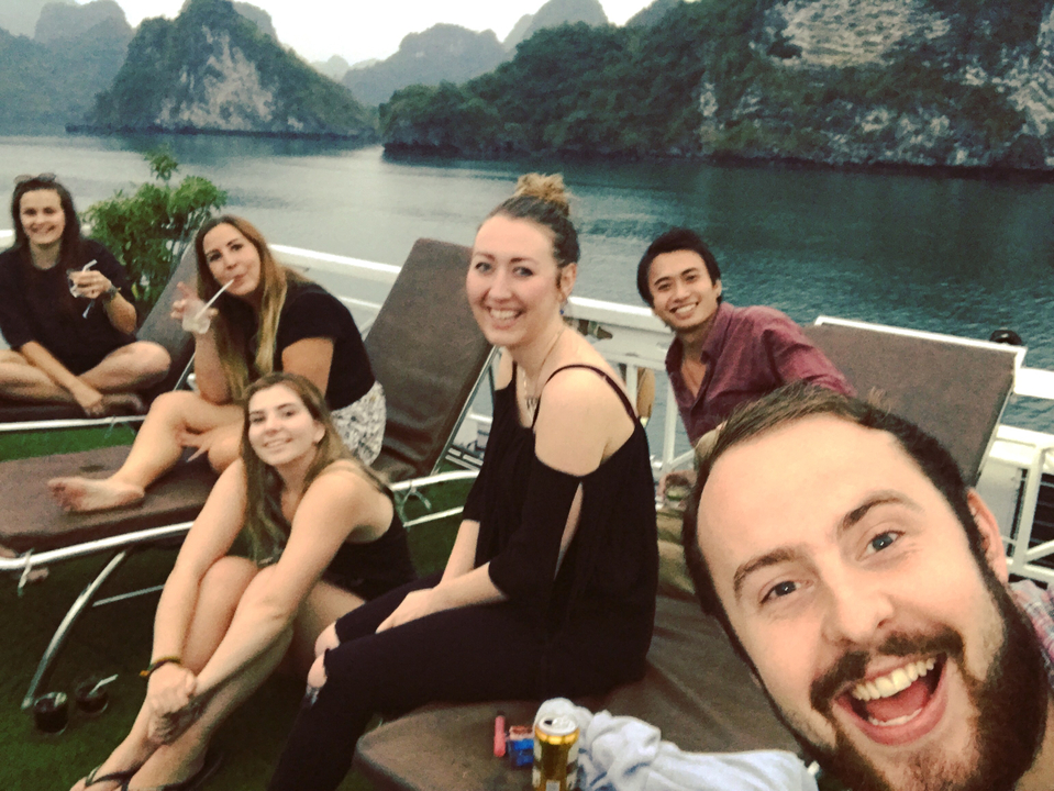Group of people relaxing on deck chairs by a body of water.