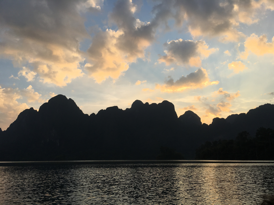 Mountains silhouetted against a colorful sunset sky.