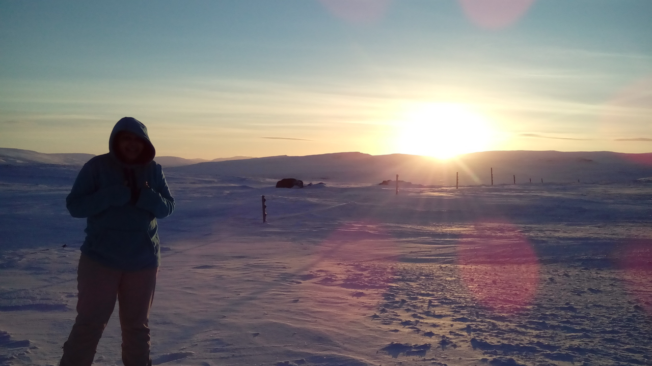 A person enjoying a scenic snowy landscape at sunrise.