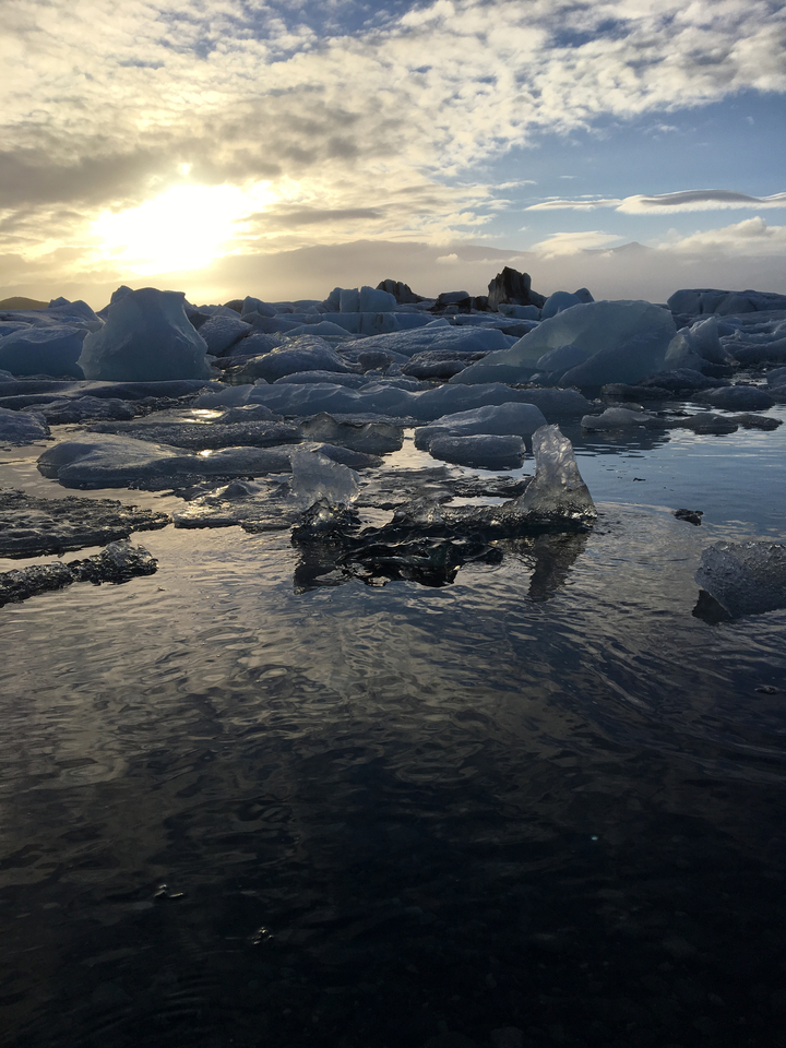 Icebergs flottant dans une étendue d'eau sereine reflétant le ciel.