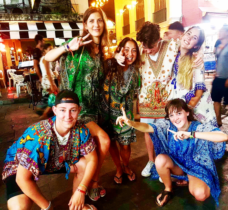 Group of young people posing, dressed in colorful traditional clothes.
