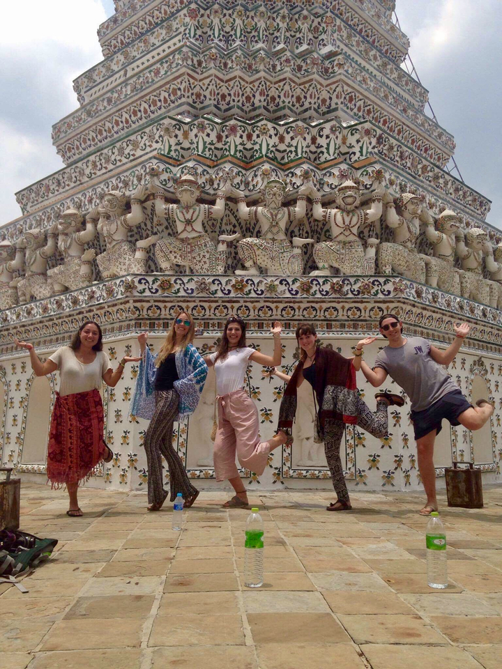 Group of people posing in front of a detailed temple facade.