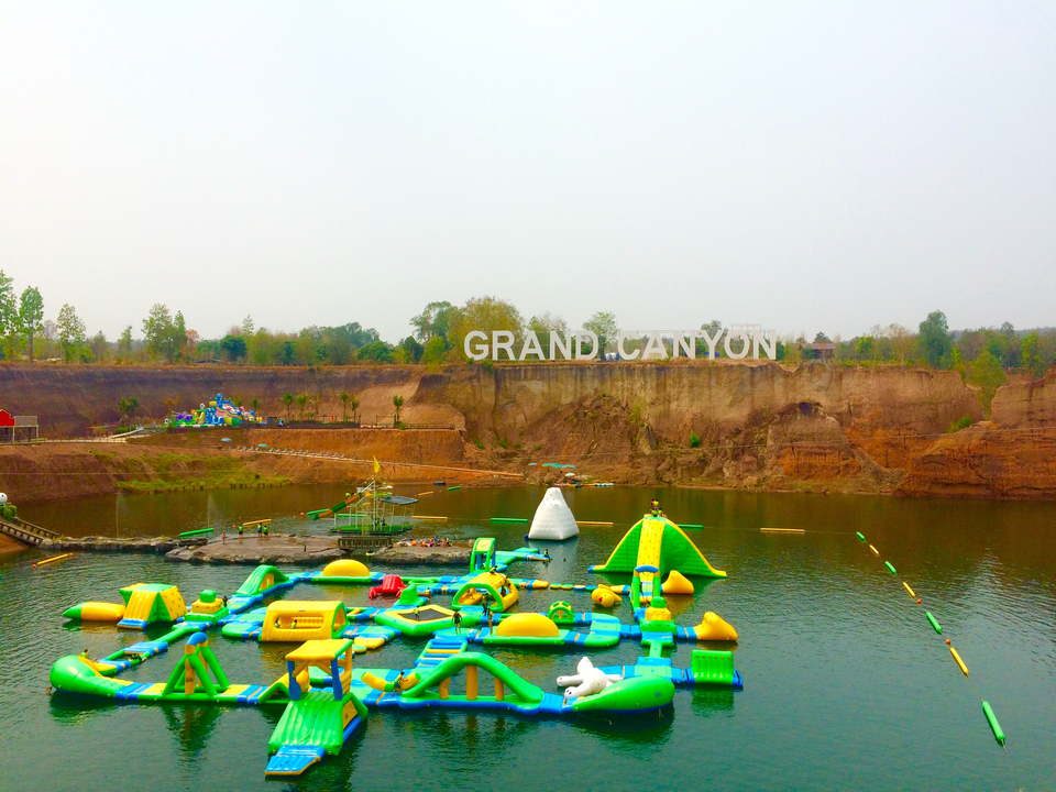 Water park setup on a large body of water with cliffs in the background.